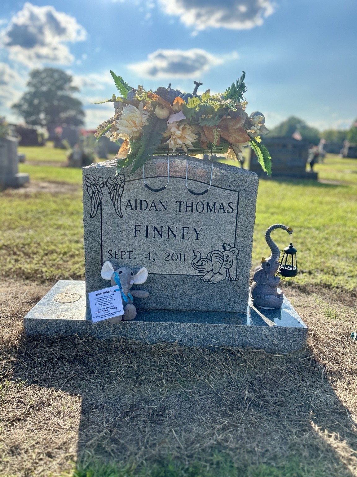 Aidan's memorial with flowers and elephants